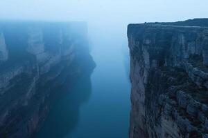 A man stands on a cliff overlooking a river photo
