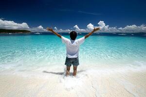 A man standing on the beach with his arms outstretched photo