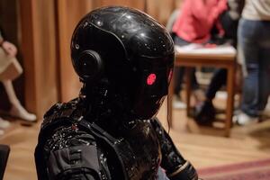 A robot with red eyes sitting on a table photo