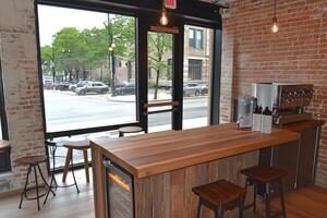 A bar with stools and a counter in front of a window photo