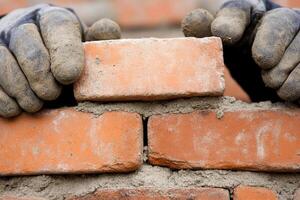 A person wearing gloves and a pair of gloves is holding bricks photo