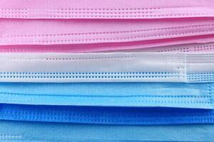 A stack of surgical masks in various colors photo