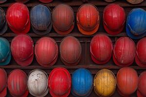 A large number of hard hats are arranged in rows photo