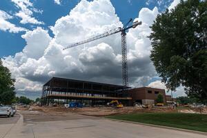 A large building under construction with a crane in the sky photo
