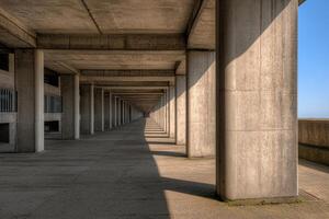 A long concrete walkway with a bench in the middle photo