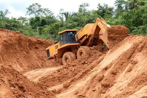 A large bulldozer is digging into the dirt photo