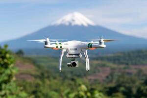 A white drone flying over a mountain with a green tree photo