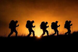 Silhouette of a group of hikers at sunset photo