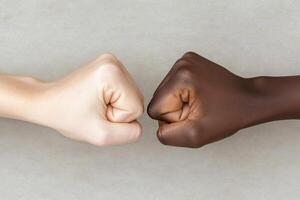 Two fists are facing each other on a gray background photo