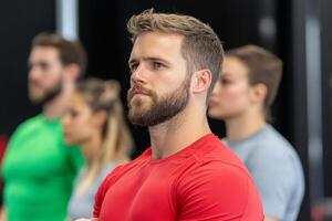 A man with a beard standing in front of a group of people photo