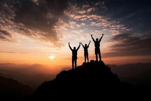 Silhouette of three people standing on top of a mountain at sunset photo