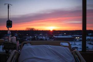 A hospital bed with a drip and a sunset in the background photo
