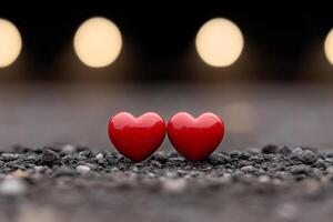 Two red hearts on the ground in front of a blurry background photo
