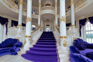 A large staircase with purple couches and gold columns photo