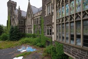 A building with many windows and a lot of weeds photo