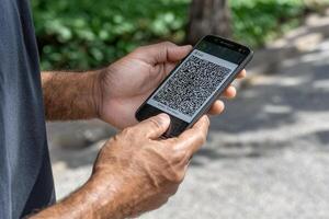 A man holding a smartphone with a qr code on it photo