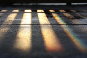 Sunlight on a sidewalk with shadows and a rainbow photo