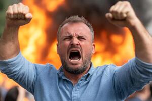 Man shouting in front of a burning building photo