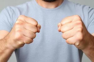 A man with his fists up against a gray background photo