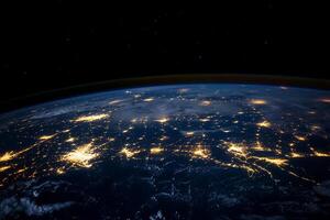 The earth at night with lights shining from space photo