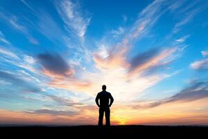 A man standing on a hill with a sky background photo