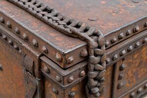 A rusty metal box with rivets and chains photo