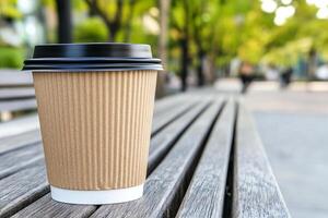 A paper cup of coffee sitting on a bench photo