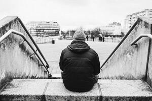 A person sitting on the steps of a building photo