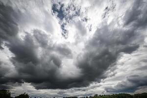 A large cloud is seen in the sky above a field photo