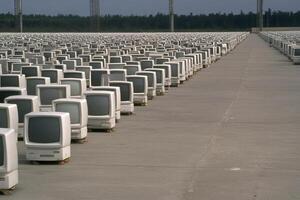 A large number of computers sitting in a row photo