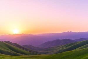 A beautiful sunset over a green hill with mountains in the background photo