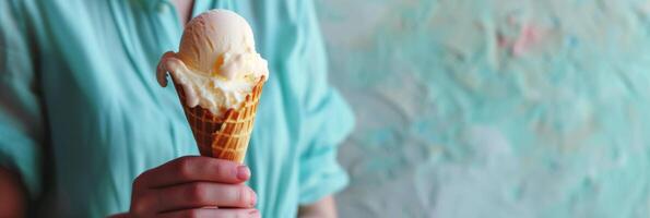 Ice cream cone in hand against a blue background photo
