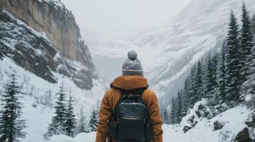 Hiking through a snow-covered valley surrounded by mountains and evergreen trees during winter photo