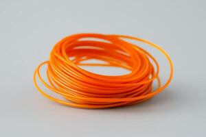 Bright orange crafting wire coiled neatly on a surface ready for creative projects and DIY activities photo