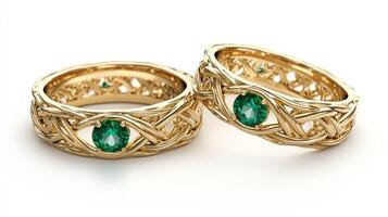 Intricately crafted gold wedding rings with green gemstones display elegance and commitment photo