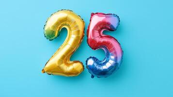 Bright rainbow foil balloon displaying the number twenty-five, viewed from above against a vibrant blue background, perfect for celebrations photo