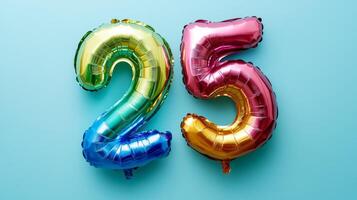 Colorful rainbow foil balloon number twenty-five viewed from above against a bright blue background, perfect for celebrating special occasions photo