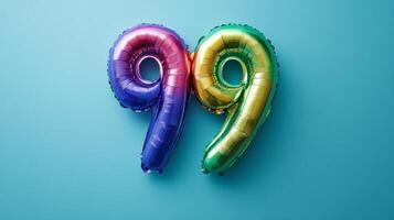 Colorful rainbow foil balloon displaying the number twenty-nine set against a vibrant blue background photo
