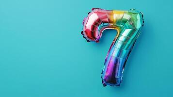 Colorful rainbow foil balloon number twenty-seven against a bright blue background perfect for celebrations or birthday parties photo