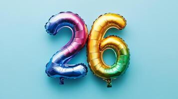 Colorful rainbow foil number twenty-six balloon displayed on a vibrant blue background for a birthday or celebration photo