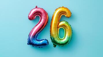 Bright rainbow foil balloon displaying the number 26 against a vibrant blue background suitable for celebrations and parties photo