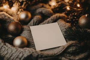A blank card surrounded by holiday ornaments on a cozy table with warm lighting for seasonal greetings or messages photo