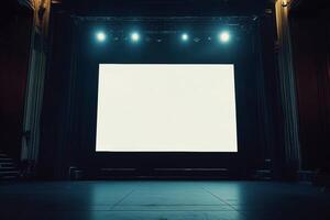 A large blank screen on stage in a concert hall illuminated by bright lights against a dark background photo