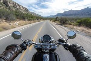 A thrilling motorcycle ride on a winding highway surrounded by stunning mountains in clear weather photo