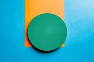 Minimalist green circle centered on vibrant blue and orange split background creating a modern art feel photo