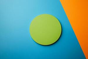 Minimalist green circle contrasting against vibrant blue and orange background for artistic inspiration photo