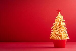 A whimsical Christmas tree made of cute french fries with a vibrant red background for festive decoration photo