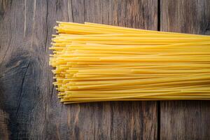 Freshly prepared spaghetti placed on a rustic wooden table, inviting and ready for a delicious meal preparation photo