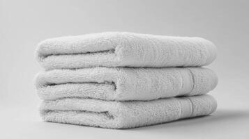 Neatly folded clean white towels arranged on a white background for a fresh and tidy appearance in any bathroom setting photo