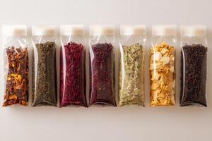 An assortment of various tea varieties stored neatly in transparent bags arranged with room for text photo
